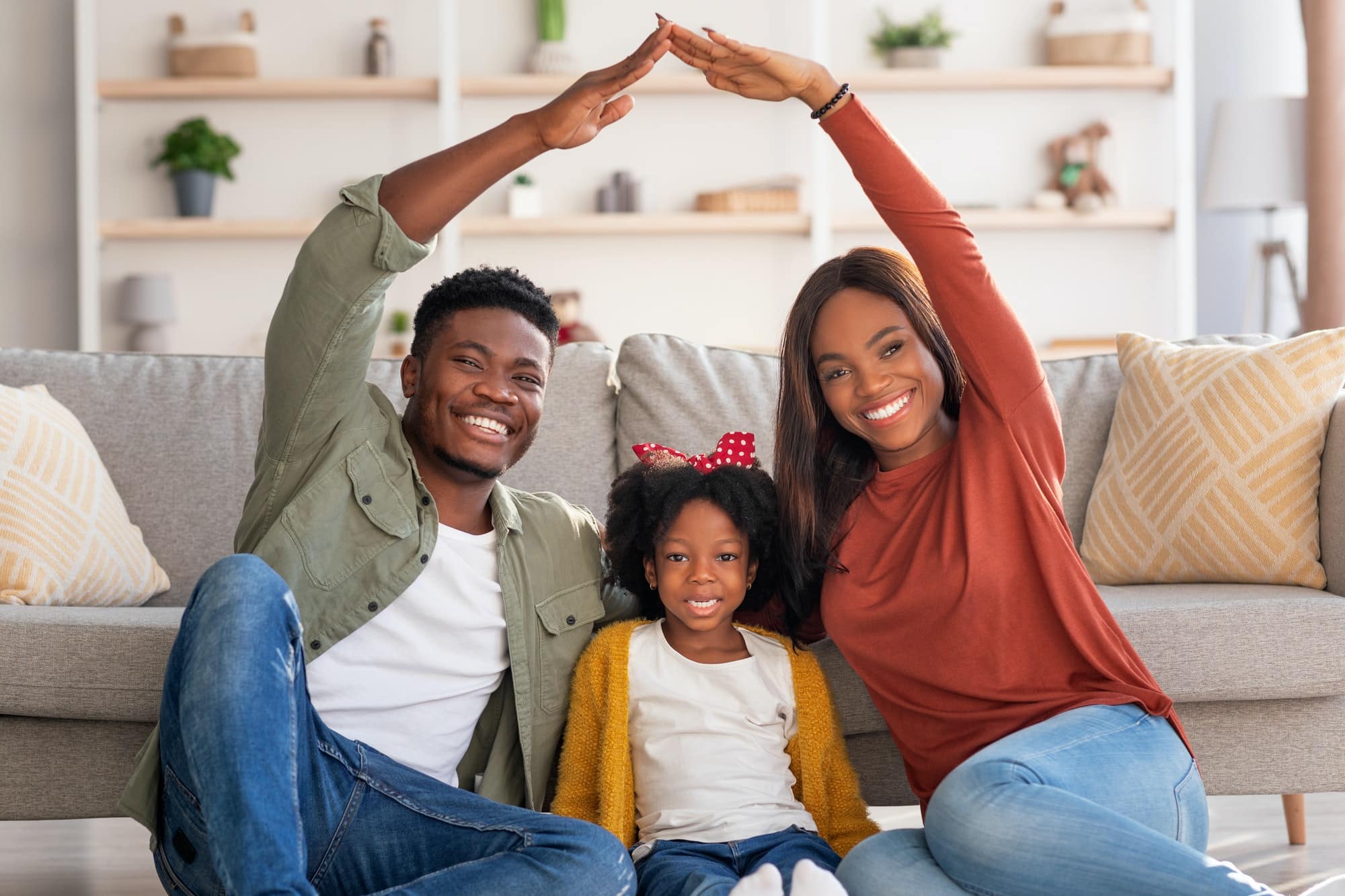 Family Housing. Black Parents Making Symbolic Roof Of Hands Above Little Daughter